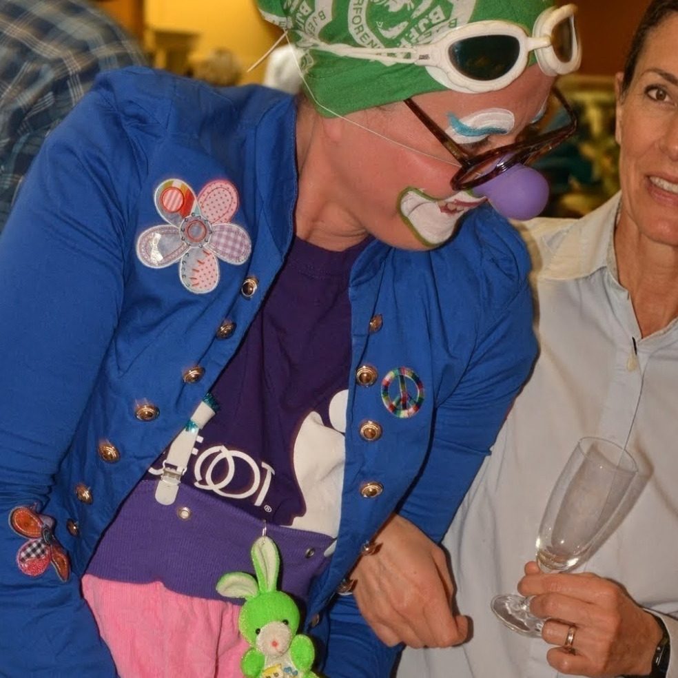 Bonjornoooo Clown mit grüner Mütze und gestreiftem Shirt, lächelt und hält Löffel.